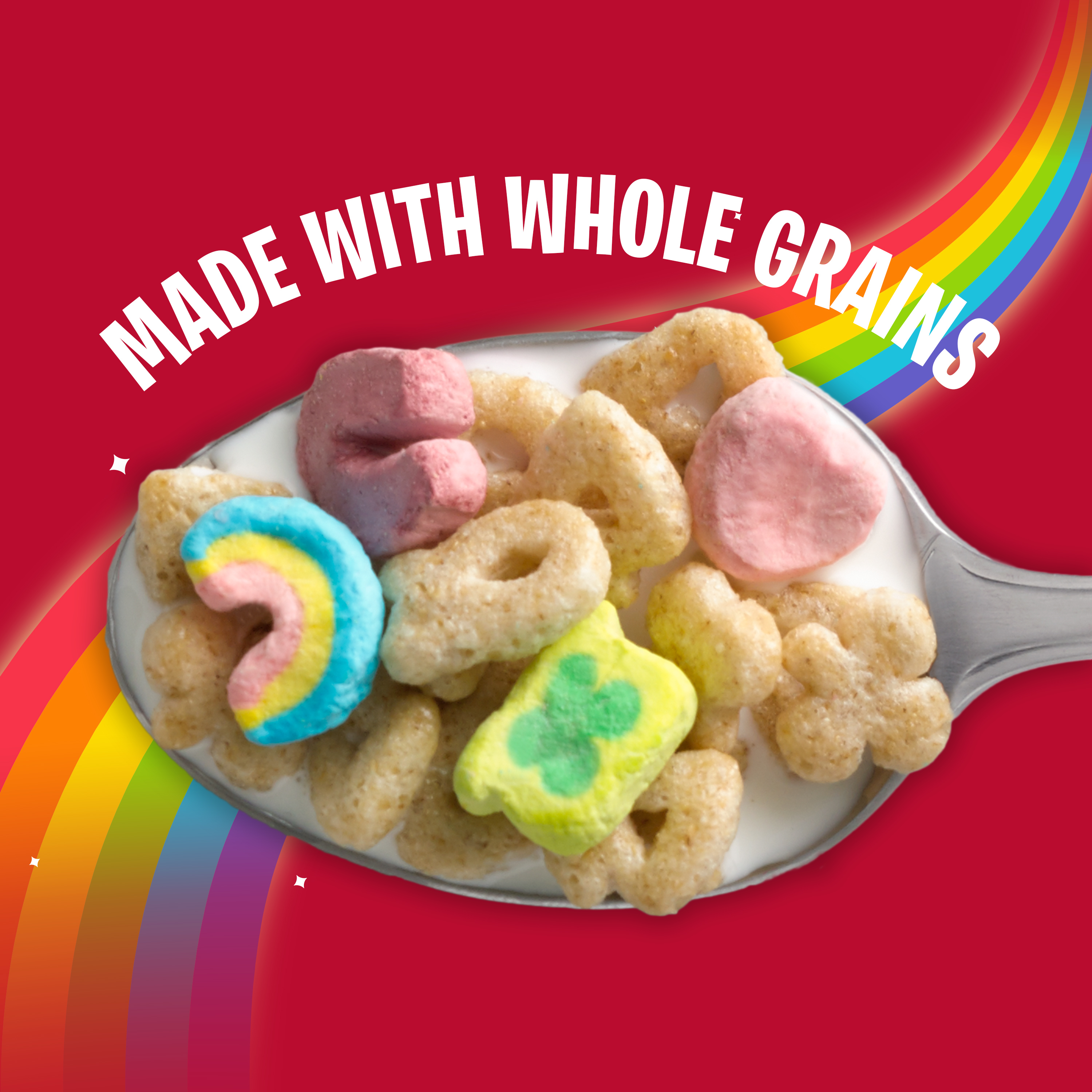 A spoon full of Lucky Charm cereal pieces with a rainbow flowing behind it