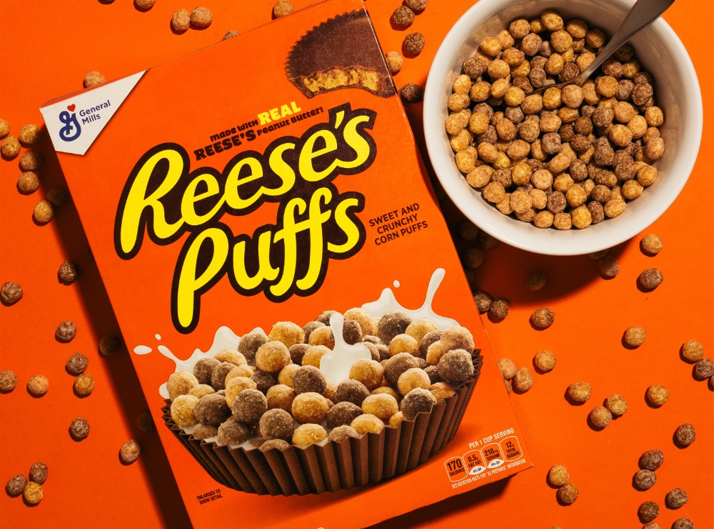 Reese's Puffs cereal box next to a bowl of cereal