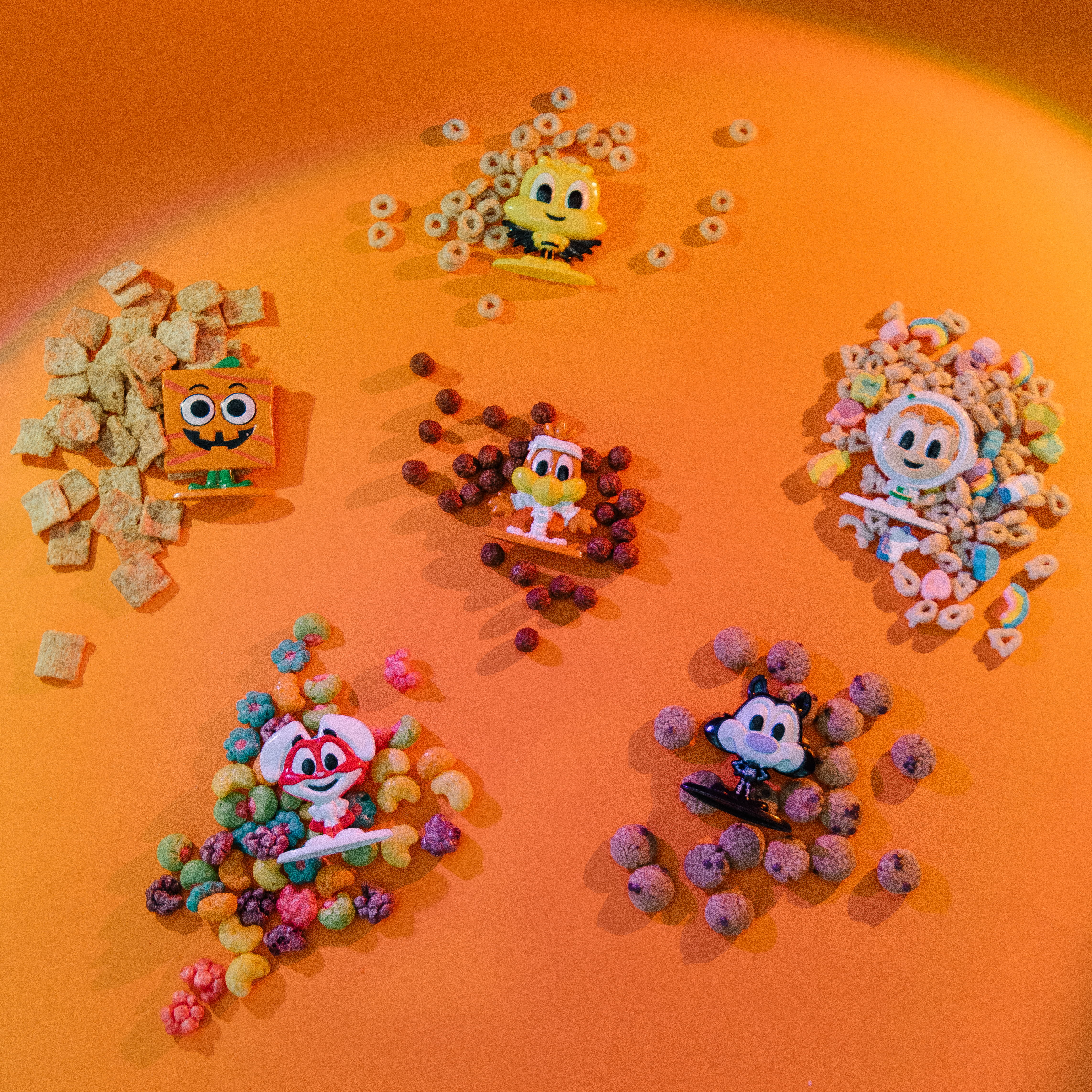 Cereal Squad toys laying on piles of cereal